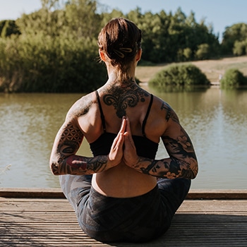 woman sitting by body of water