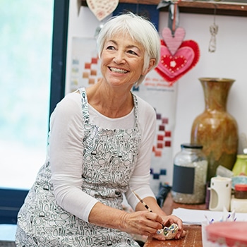 smiling woman making handcrafts 