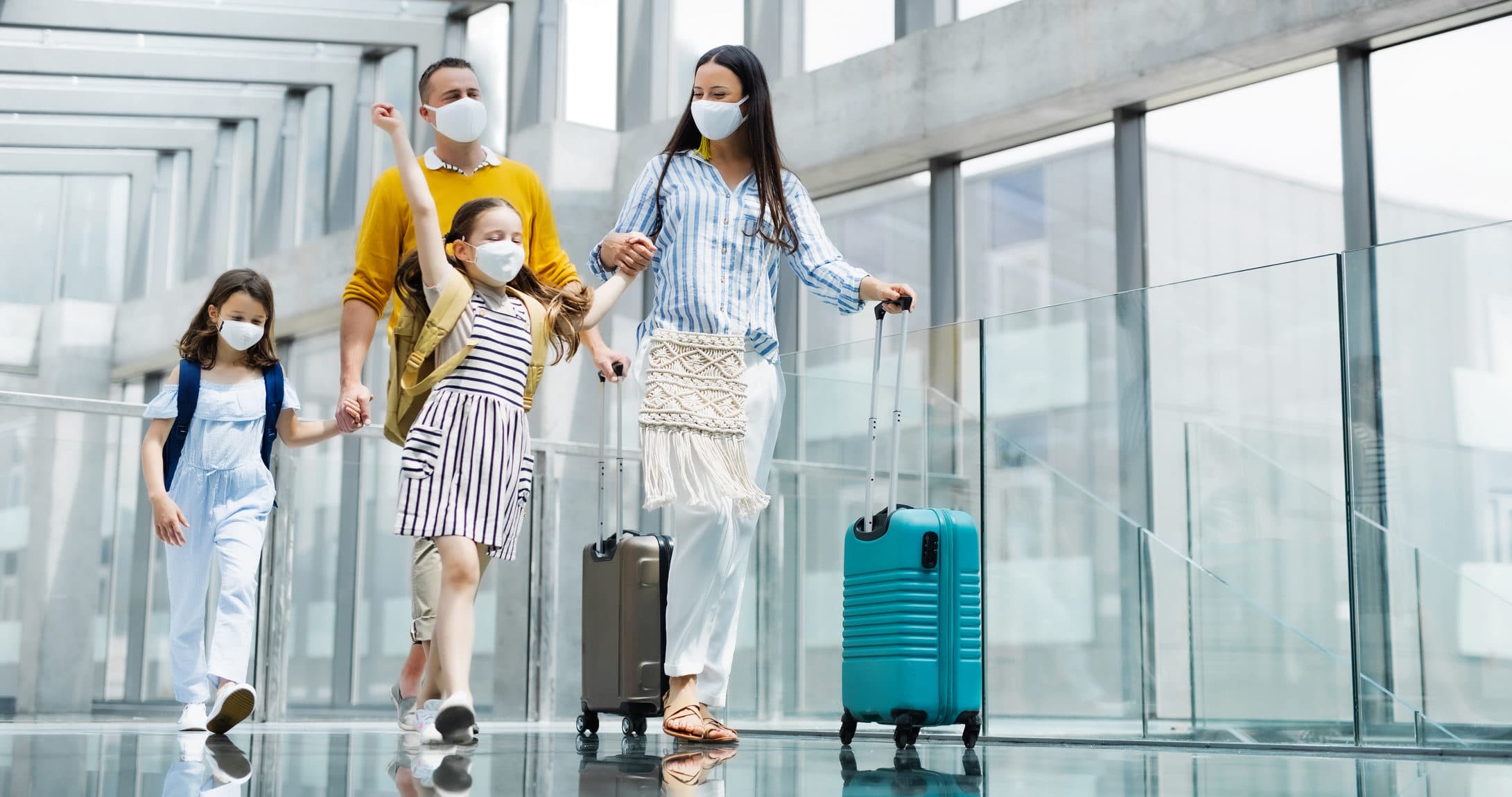 family at the airport waring face masks