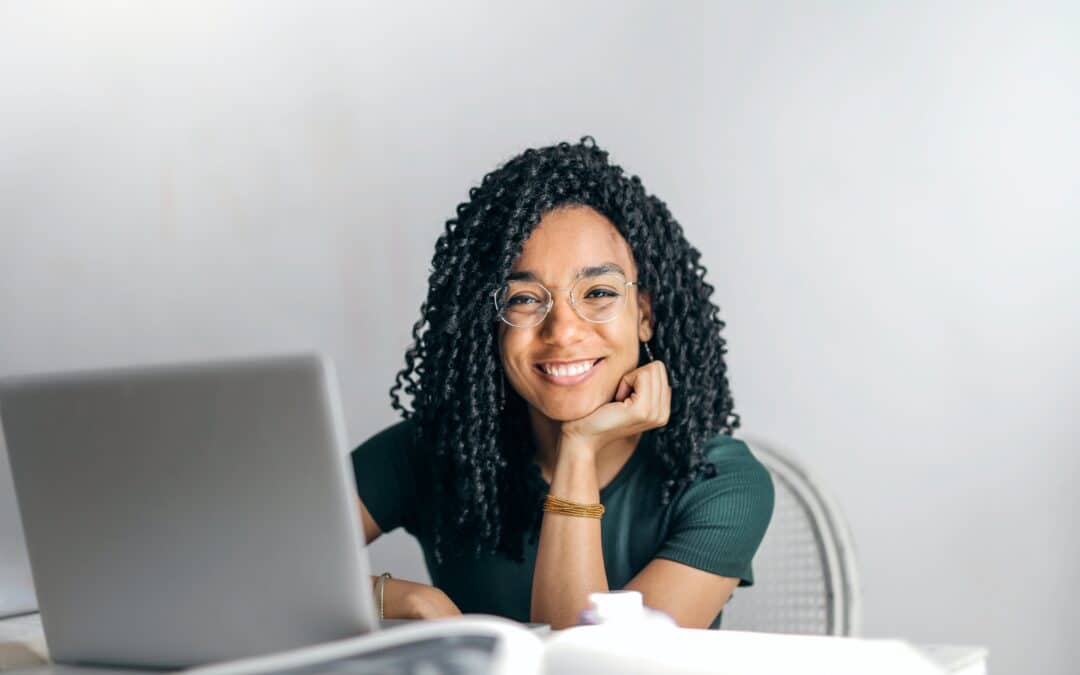 Young woman smiling in front of computer.