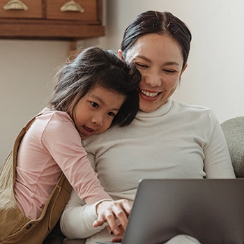 mother shops online with her child next to her